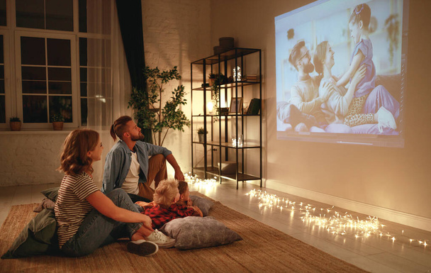 family mother father and children watching projector, TV, movies - Foto, Imagen