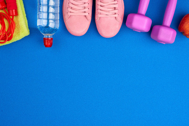 haltères en plastique violet, vêtements de sport, eau, baskets roses sur un
  - Photo, image