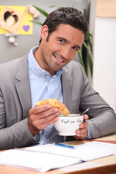 Man dipping croissant into coffee - Fotografie, Obrázek