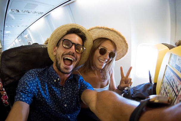 クレイジーで幸せなカップルは、飛行中に飛行機で自撮り. - 写真・画像