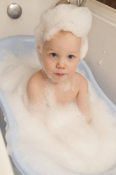 Menino banha em uma espuma
 - Foto, Imagem