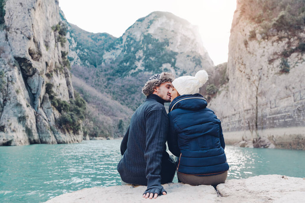 Birbirine aşık çiftler bir dağ manzarasının önünde öpüşüyorlar.  - Fotoğraf, Görsel