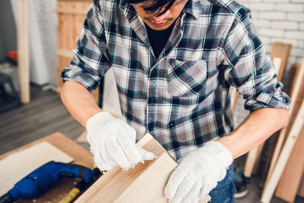 El hombre carpintero está trabajando la carpintería de madera en la tienda de carpintería, el artesano está atornillando el marco de madera para muebles de madera en el taller. Ocupación Laboral y Obra Laboral Concepto
 - Foto, imagen