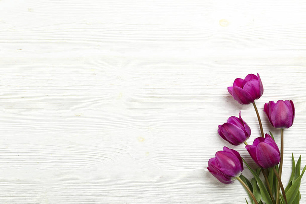 Egy csomó tavaszi virág a texturált asztal hátterében, sok másolási hellyel a szövegnek. Felülnézet, közelről, lapos kompozíció. - Fotó, kép