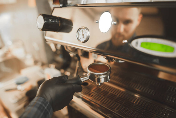 Barista tartja a kezében a tulajdonosa, a frissen őrölt kávé, közelről. Főzés kávét a kávézóban. Kávé kultúra fogalma. Háttér - Fotó, kép