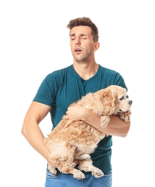 Young man with pet allergy on white background - Photo, Image