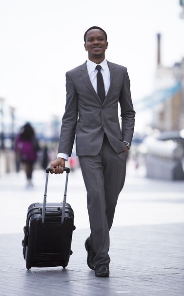 African American businessman pulling suitcase - Фото, зображення