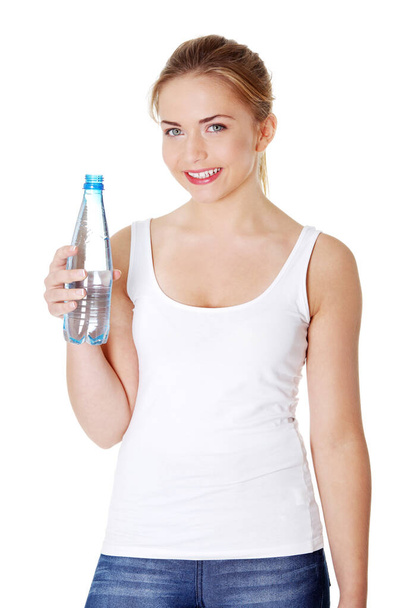 Teen woman drinking mineral water from bottle - Foto, afbeelding
