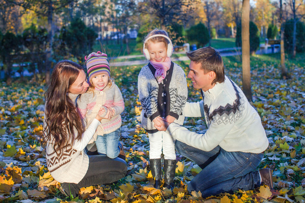 Jeune belle famille de quatre personnes a apprécié se détendre dans le parc d'automne
 - Photo, image