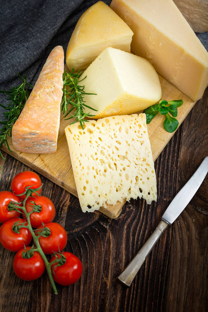 Cheeses with basil, rosemary and tomatoes. - Photo, image