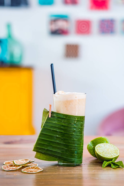 Close-up of banana milk smoothie with drinking straws served in a tall glass. - Photo, Image
