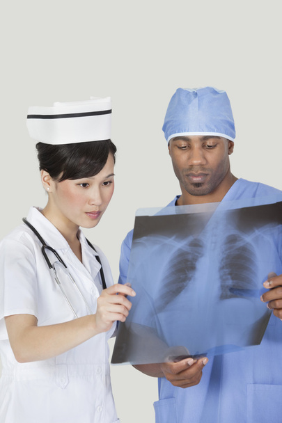 Surgeon with nurse examining x-ray report - Photo, image