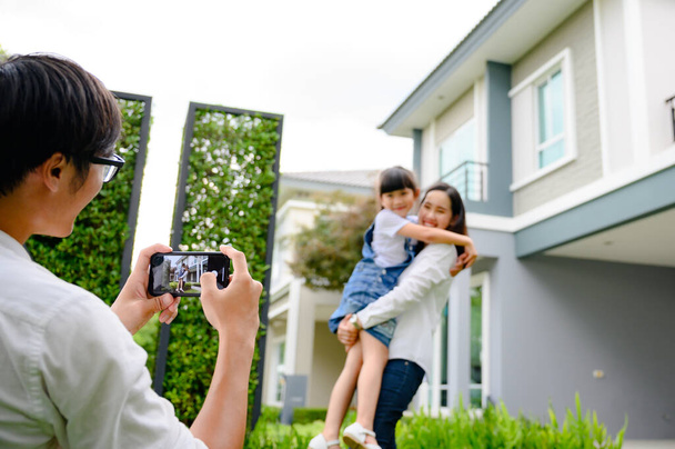 hand of father holding mobile device taking picture family with dreaming home, new family meeting new home buying - Foto, Imagem
