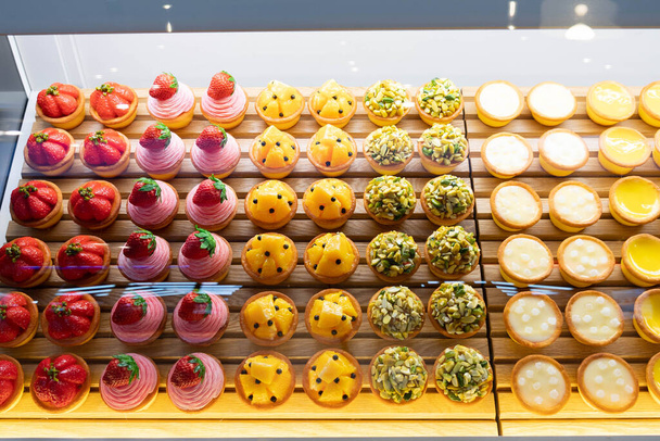 Top view afbeelding van fruit taarten die worden weergegeven op een transparante opslag. - Foto, afbeelding