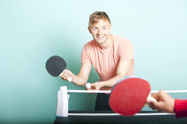 Man playing table tennis with friend - Фото, зображення