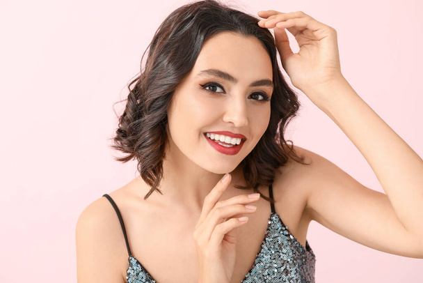 Красивая молодая женщина со стильным макияжем на цветном фоне - Фото, изображение