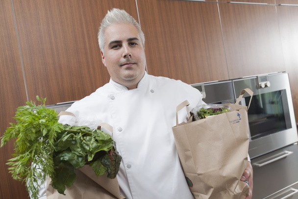 Mid- adult chef with two bags of fresh groceries - Zdjęcie, obraz