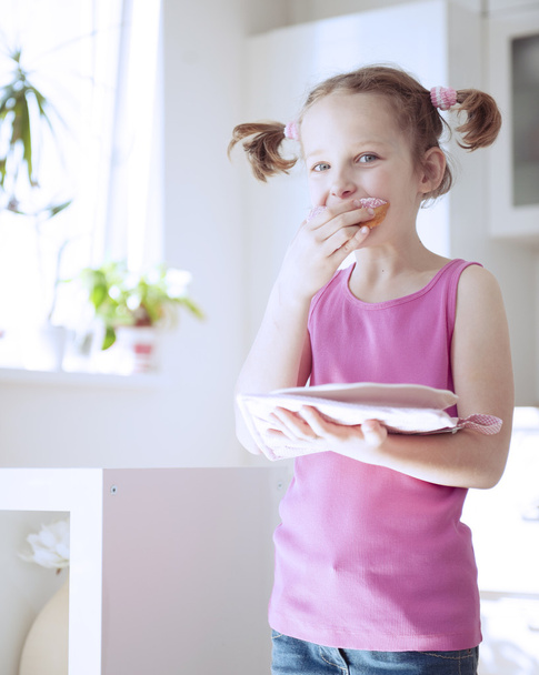 Girl eating cake in kitchen - Fotó, kép