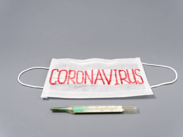 antivirale Gesichtsmaske auf grauem Hintergrund. Coronavirus-Epidemie. - Foto, Bild