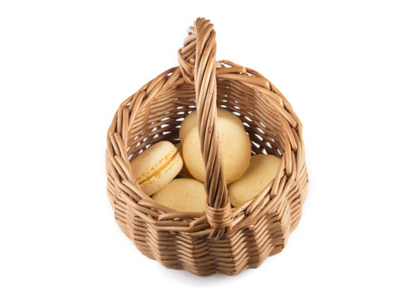 macarrones amarillos en una cesta de madera de mimbre sobre un fondo blanco
 - Foto, Imagen