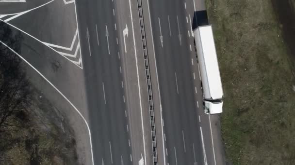 Vista aérea del coche SUV crossover que conduce a lo largo de la carretera de grava vacía a través de prados verdes paisaje en la mañana soleada. Drone persiguiendo un coche
. - Metraje, vídeo
