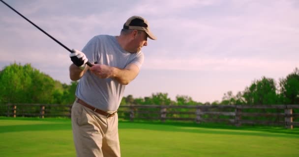 Handsome older golfer swinging golf club, golfing in paradise. - Footage, Video