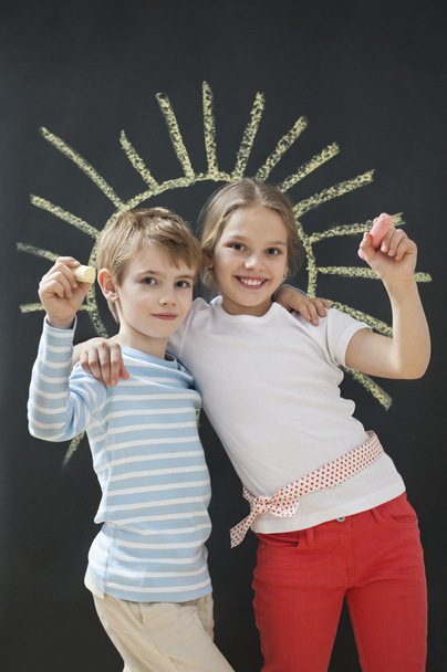 Siblings holding chalks - Foto, afbeelding