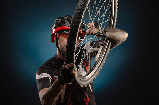 férfi-kerékpáros egy kerékpáros sisak kerékpárkerékkel - Fotó, kép