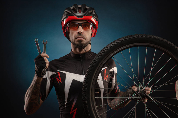 хлопець-велосипедист у велосипедному шоломі з велосипедним колесом
 - Фото, зображення