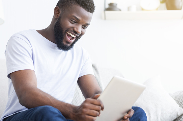 Excited african american guy enjoying sports translation online - Photo, Image