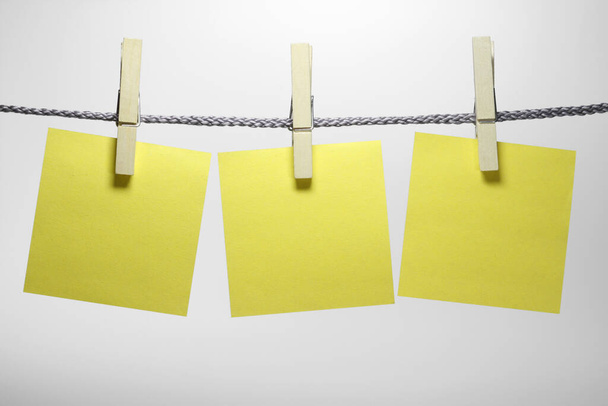 three clothespins with sticky notes hang from a string. - Foto, Imagem
