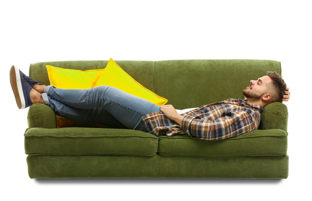 Молодий чоловік розслабляється на дивані на білому тлі
 - Фото, зображення