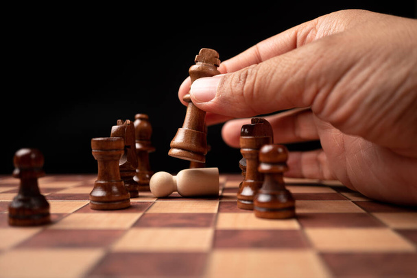 Κοντινό πλάνο του επιχειρηματία με αυτοπεποίθηση κινείται σκακιστική φιγούρα στο παιχνίδι της επιτυχίας του ανταγωνισμού. το παιχνίδι σκάκι είναι η ανάλυση ανάπτυξης, η στρατηγική και το σχέδιο, η έννοια της διαχείρισης ή της ηγεσίας. - Φωτογραφία, εικόνα