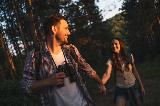 Happy couple fait de la randonnée en forêt dans l'après-midi
. - Photo, image