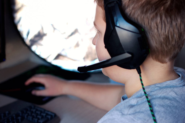 Концепция поколения Z. Вид сзади подростка в наушниках, играющего в компьютерные игры
. - Фото, изображение