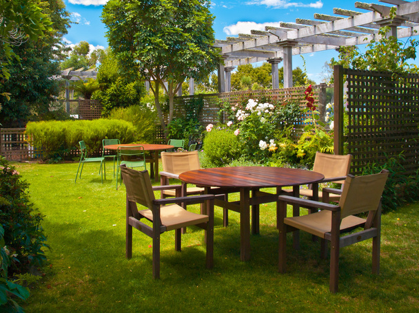 обеденный стол в пышном саду
 - Фото, изображение