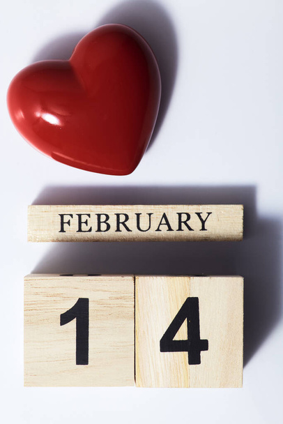 Punainen sydän muotoinen kuutio kalenterin varjossa
 - Valokuva, kuva