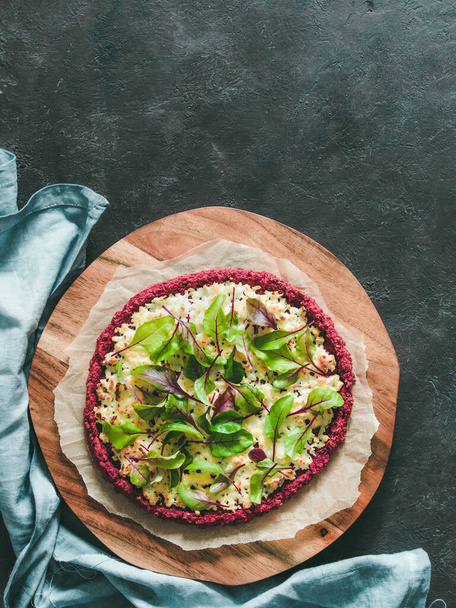 beetroot pizza crust with fresh swiss chard or mangold beetroot leaves.Ideas and recipes for healthy vegan snack.Egg-free pizza crust with chia seed and wholegrain brown rice flour.Copy space.Top view - Φωτογραφία, εικόνα