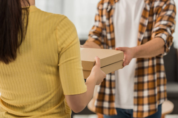Cropped view of courier giving pizza in boxes to man - Photo, Image