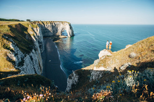 Couple looking at Etretat cliffs along the ocean shore in France - Foto, afbeelding