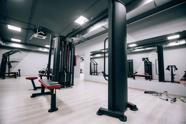 Modern light gym. Sports equipment in gym. Barbells of different weight on rack - Photo, Image