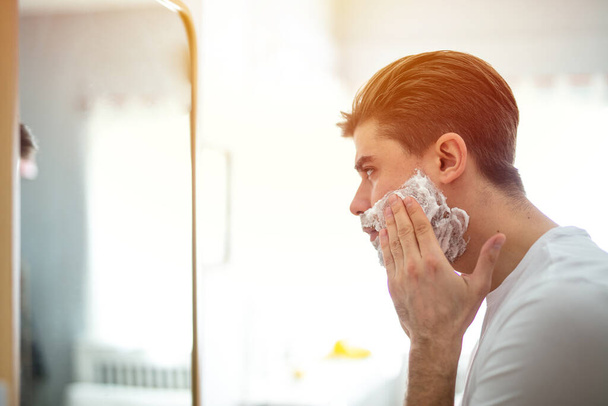 man laying his foam on his face, preparing to shave - Photo, image