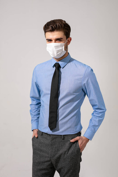 ウイルス対策の服を着て感染症に対する口の保護を身に着けているネクタイでエレガントな男 - 写真・画像