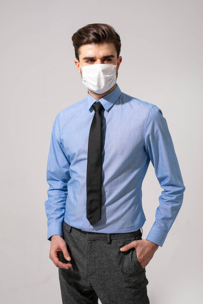 outfit with virus protection. elegant man with tie wearing a mouth protection against contagious diseases - Фото, зображення
