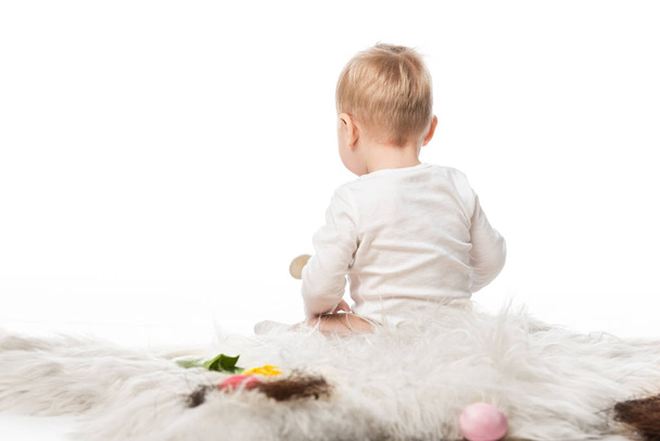 Rückseite von niedlichen Kind sitzt auf Fell isoliert auf weiß - Foto, Bild