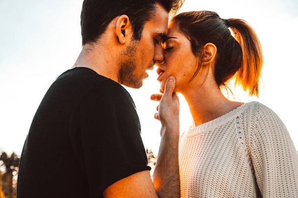 Casal amoroso beijando ao ar livre ao pôr do sol - Conceito sobre as pessoas, amor e estilo de vida
 - Foto, Imagem