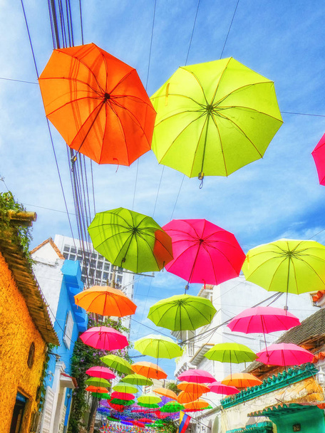 Kuja täynnä värikkäitä kelluvia sateenvarjoja
 - Valokuva, kuva