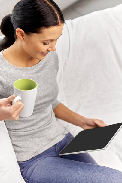 young woman with tablet computer and mug at home - Φωτογραφία, εικόνα