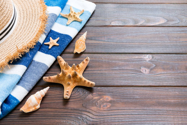 Cappello di paglia, asciugamano blu e stelle marine Su uno sfondo di legno scuro
.  - Foto, immagini