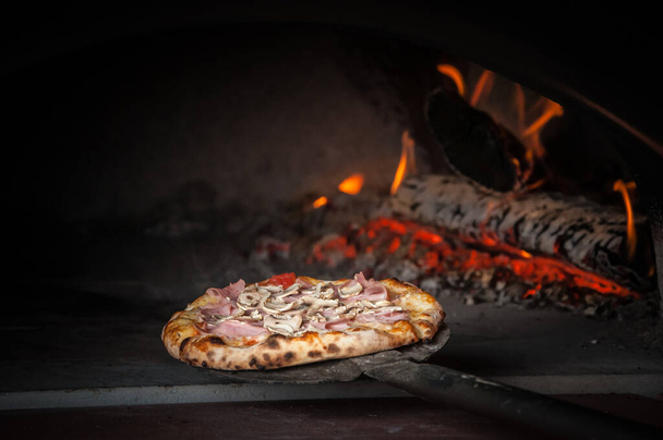 Pizza baking in traditional stone oven - Foto, imagen